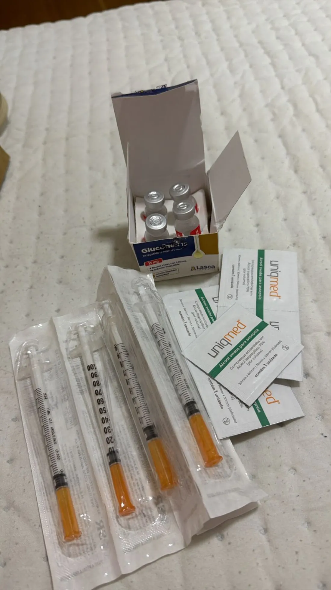 Caixa de Gluconex 15 aberta com os frascos, seringas e swabs de álcool recebidos